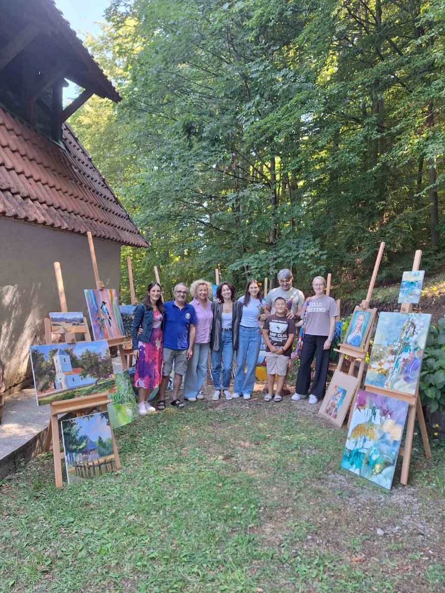 ljudi oba pola poziraju ispred štafelaja