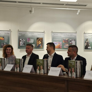 Три мушкарца и жена седе на представљању