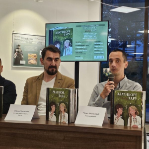 Два мушкарца седе. Један говори, други гледа у њега