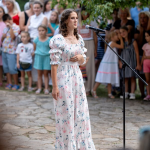 Devojka peva ispred mikrofona