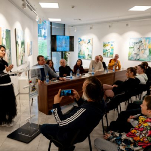 zena govori za govornicom. Pored sede pesnici
