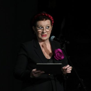 zena gleda u publiku dok govori na mikrofon