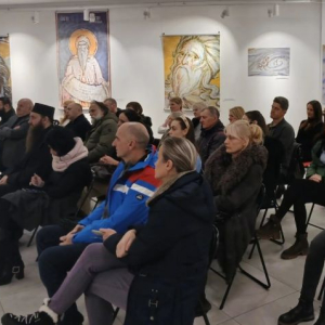 ljudi sede u publici i slusaju govornike