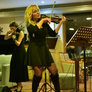 zena blago povijenih kolena svira violinu
