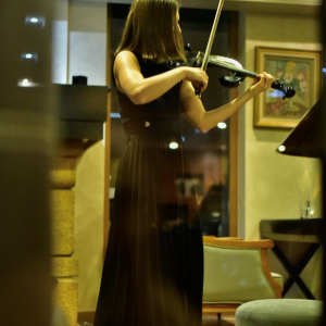 zena u crnoj suknji svira violinu