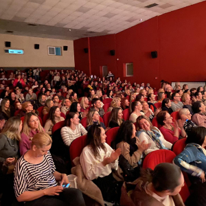 zene i muskarci sede i cekaju predstavu