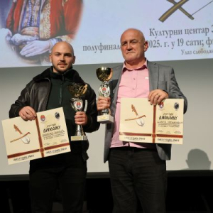 dva coveka drze plakete i pehare