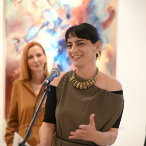 crnokosa zena govori gestikulirajuci rukom