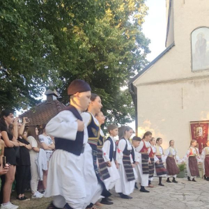 decak sa sajkacom predvodi kolo pred crkvom