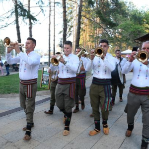 ljudi u narodnoj nošnji sviraju trube