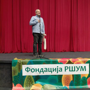 covek u kosulji prica u mikrofon