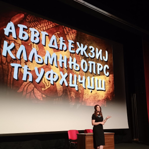 zena govori iza nje na platnu ćirilica