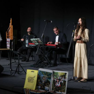 devojcica peva, iza nje orkestar