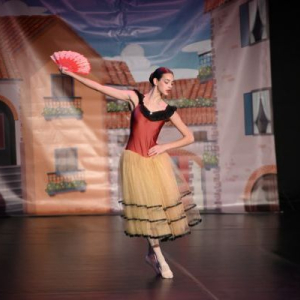 balerina u zutoj suknji sa lepezom u desnoj ruci