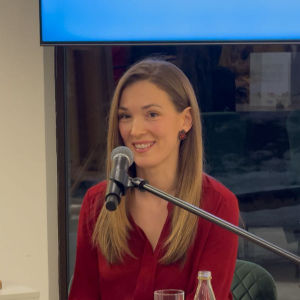 devojka sedi i prica u mikrofon