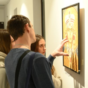 muskarac i dve dvojke analiziraju sliku 