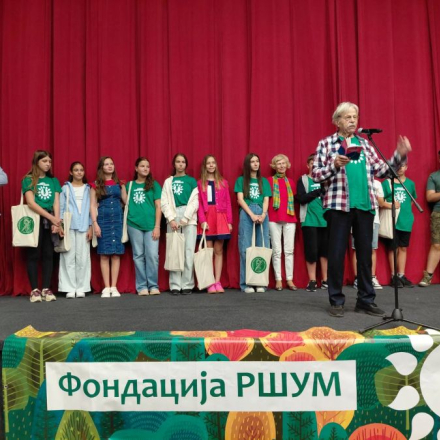 deca na sceni ispred njih stoji odrastao covek i recituje